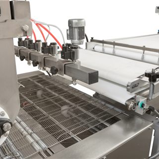 Dough depositor and conveyor detail on a bakery production line