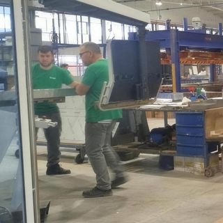 Technicians positioning an equipment panel during installation