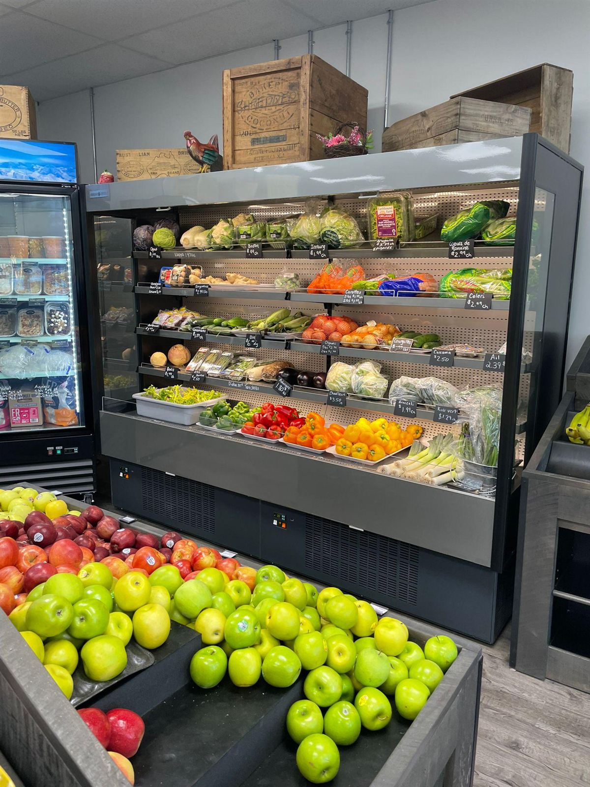 Open produce display case stocked with fruit and vegetables in a grocery installation
